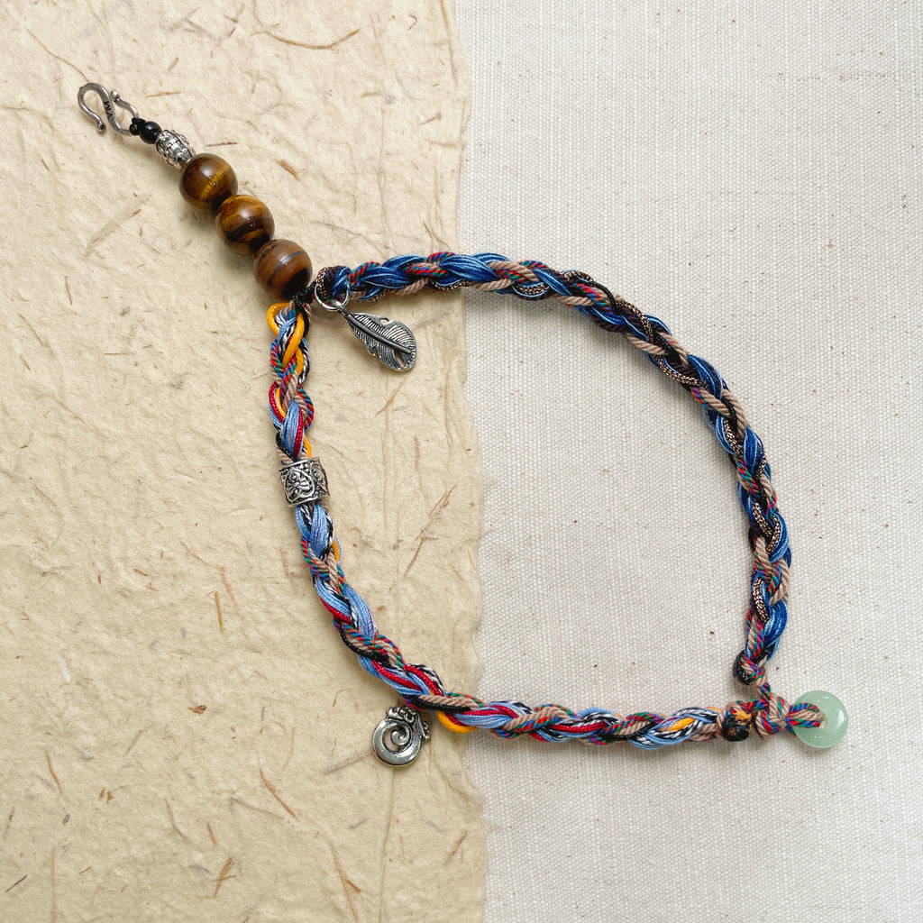 Woman wearing colorful woven stone bracelet on wrist, adjustable hippie style wristband.