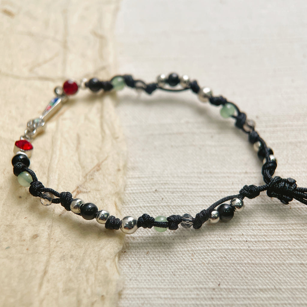 Adjustable black string bracelet on wrist, simple everyday boho jewelry for men and women.
