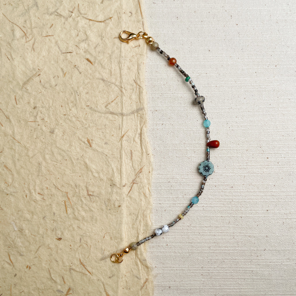 Delicate colorful glass bead bracelet on wrist, minimalist gold accent jewelry.
