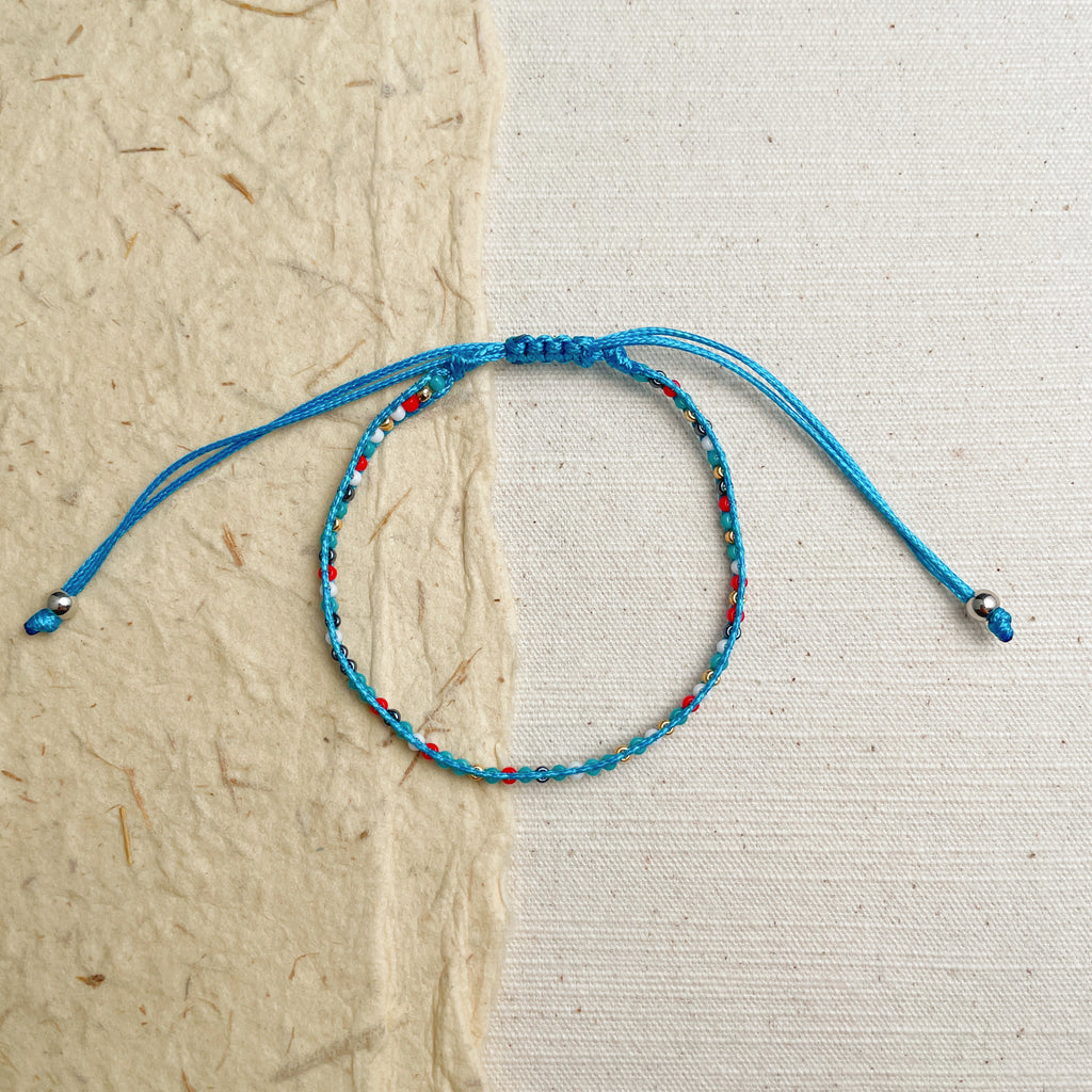 Layered turquoise and leather bracelets on wrist, adjustable summer boho set.