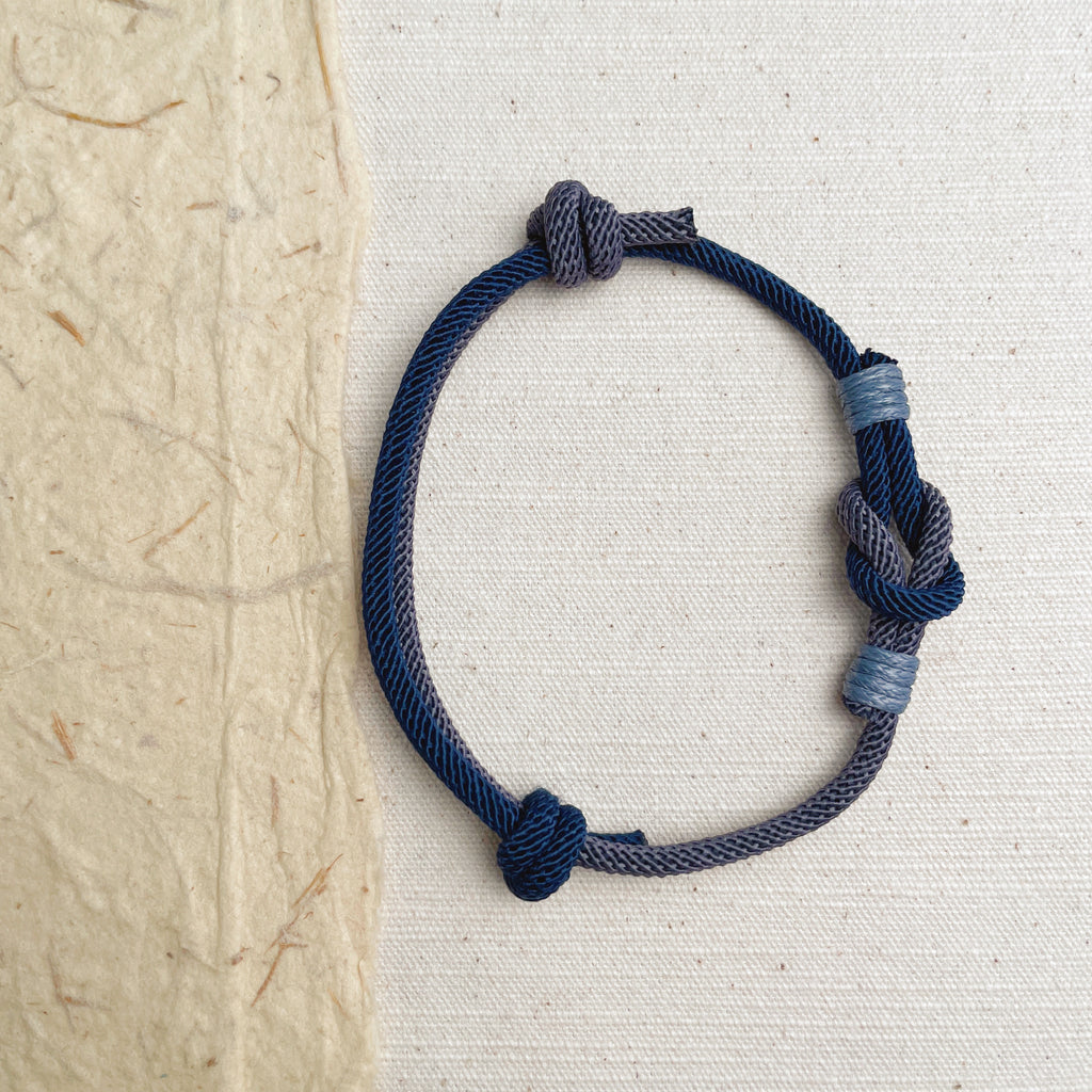 Handmade blue and gray braided cord bracelet, minimalist woven jewelry.