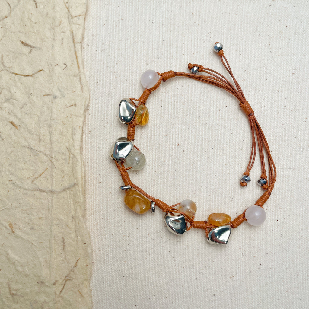 Unisex woven gemstone bracelet on wrist, grounding energy adjustable jewelry.