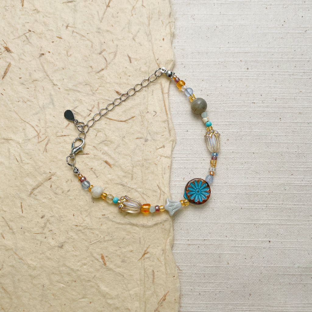 Handmade boho gemstone bracelet with floral charm, colorful glass bead jewelry.