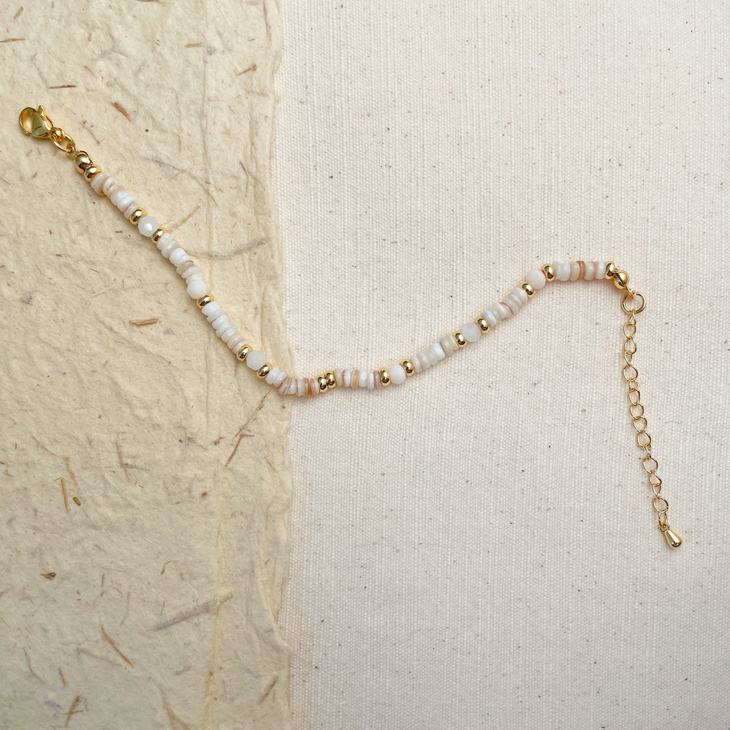 Adjustable white and gold beaded bracelet on wrist, elegant boho jewelry gift.