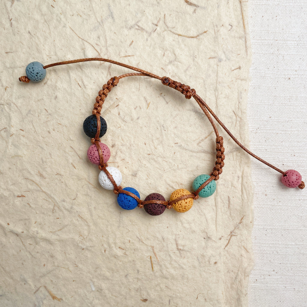 Colorful aromatherapy bracelet on wrist, adjustable lava stone energy jewelry.