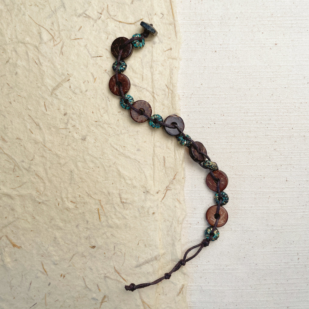 Natural coconut shell bracelet on wrist, brown boho organic jewelry.