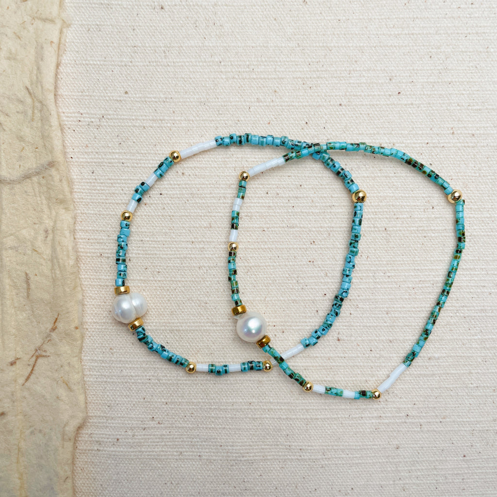 Stackable turquoise and pearl bracelets on wrist, 2-piece coastal jewelry set.