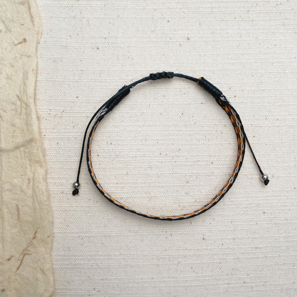 Handmade black woven cord bracelet, geometric diamond pattern protection jewelry.