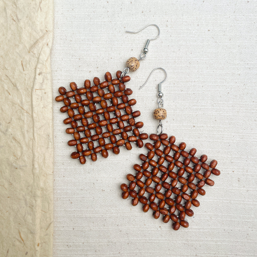 Rustic wooden earrings on woman, brown woven boho jewelry for festivals.