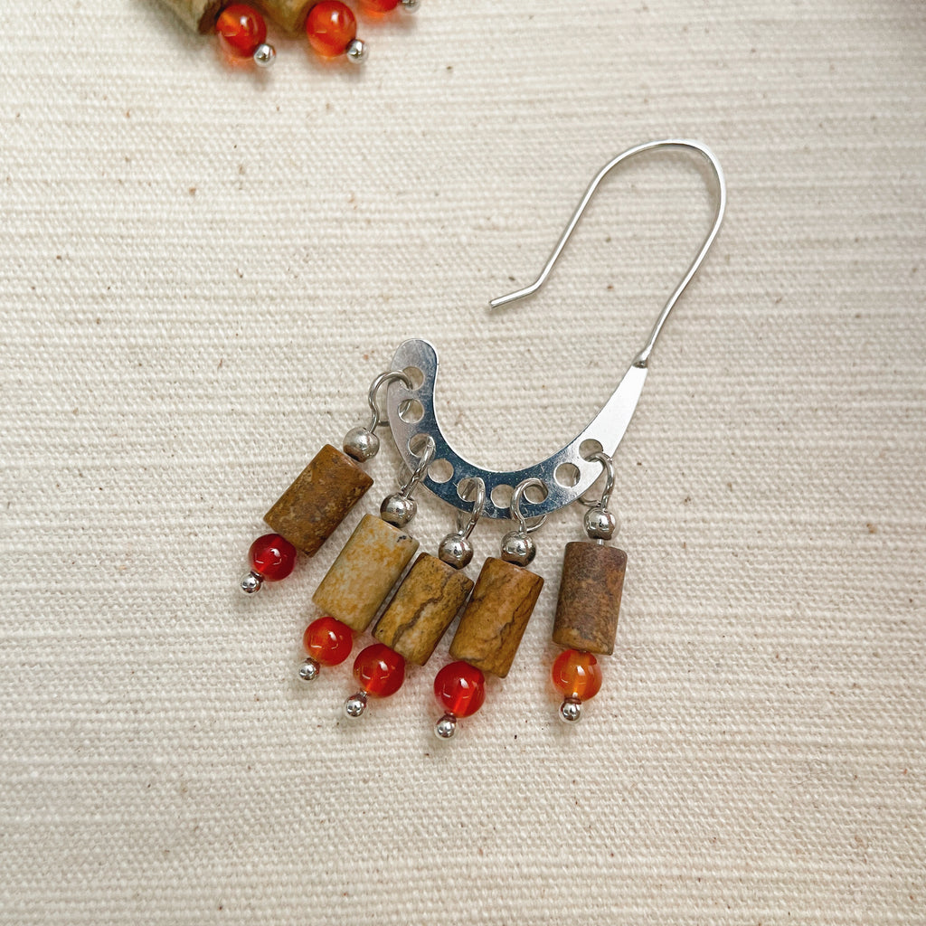Rustic gemstone dangle earrings on woman, matte brown and orange western jewelry.