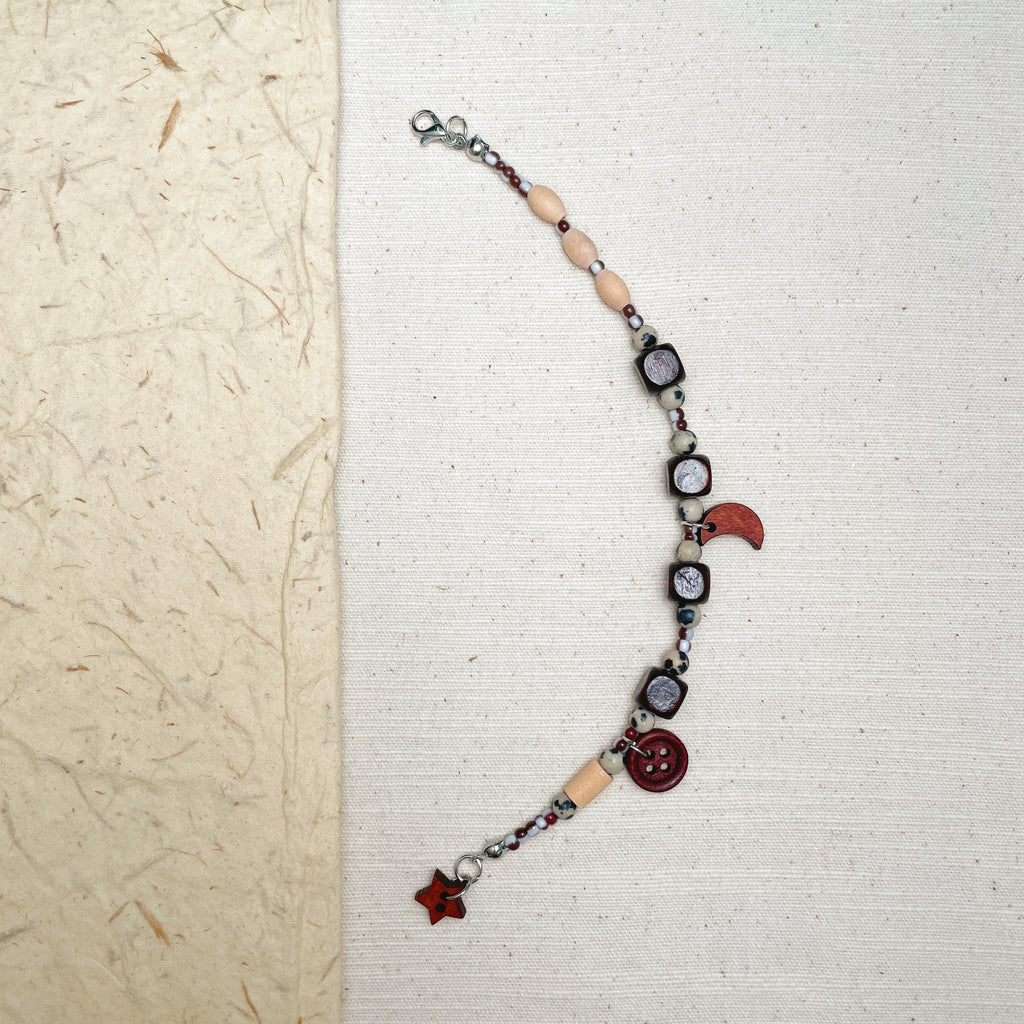 Handmade dalmatian jasper bracelet with wooden moon and star charms, naturecore jewelry.