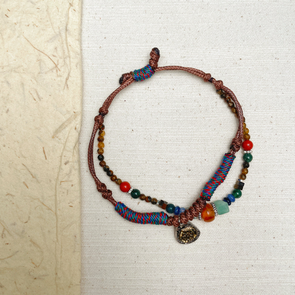 Handmade Tibetan style bracelet with lucky coin charm and mixed gemstones.